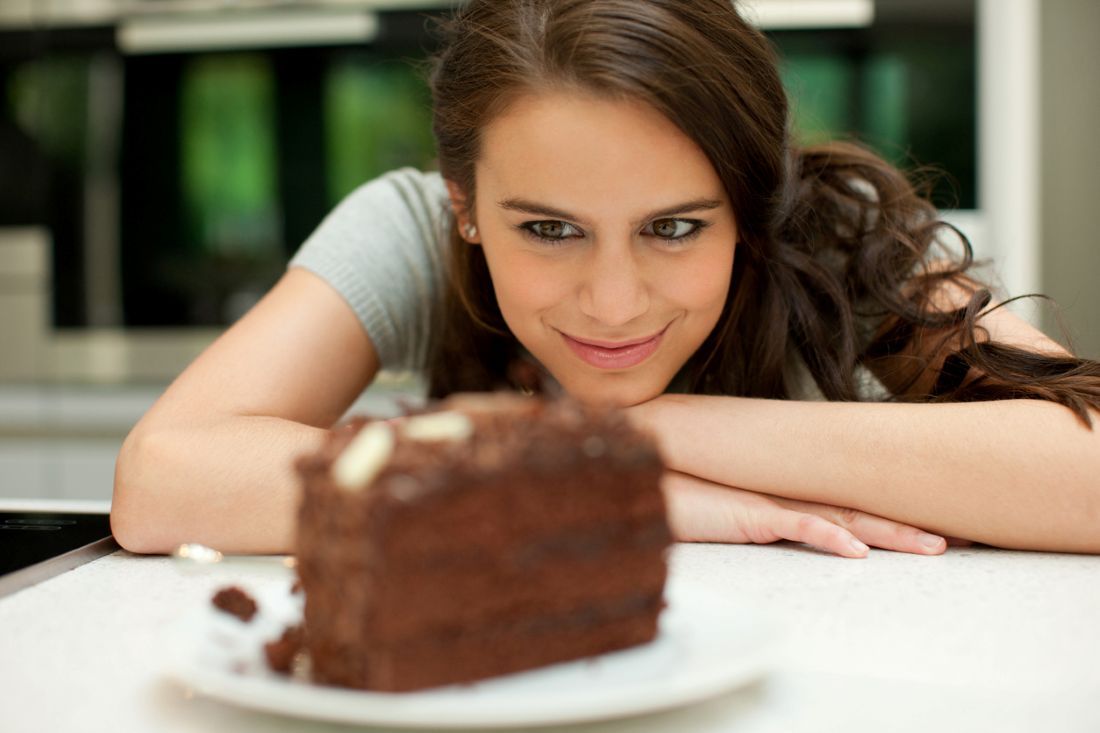 Frau schaut auf Schokoladenkuchen