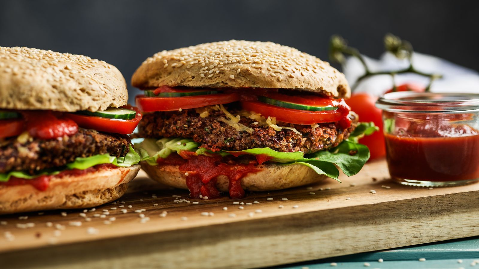 Vegane Burger aus Bohnen und Quinoa auf Holzbrett serviert