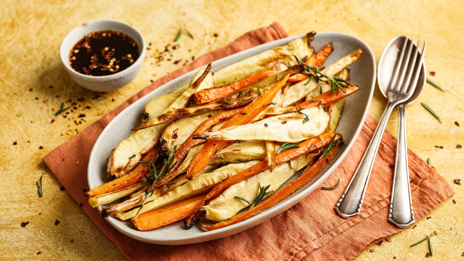 Pastinaken und Karotten vom Blech serviert in einer längliche Schale