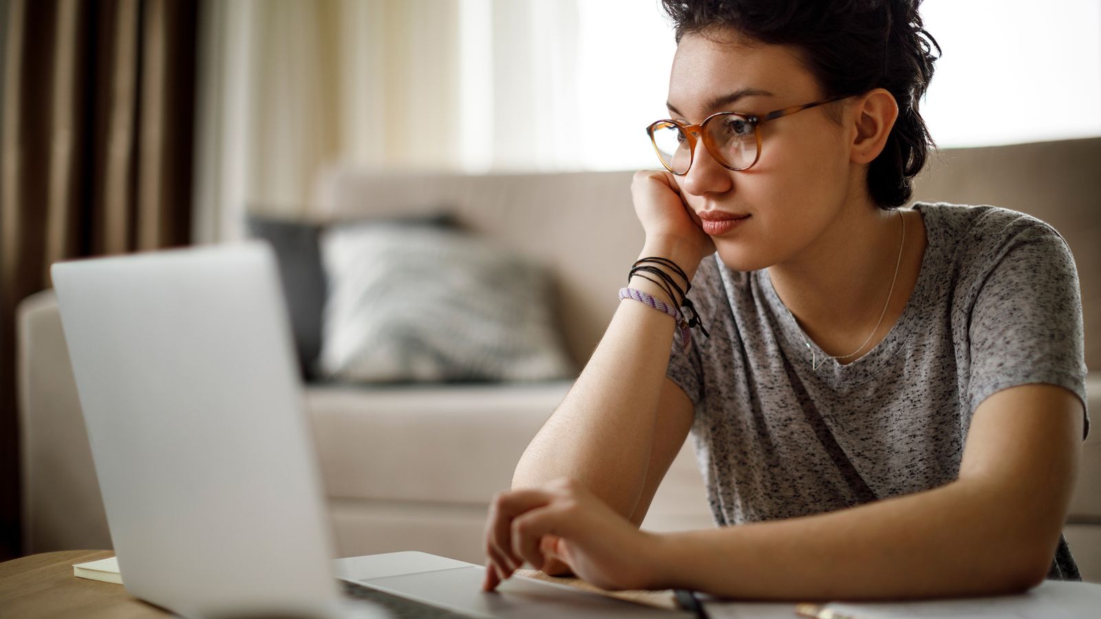 Young woman is sitting in front of a laptop