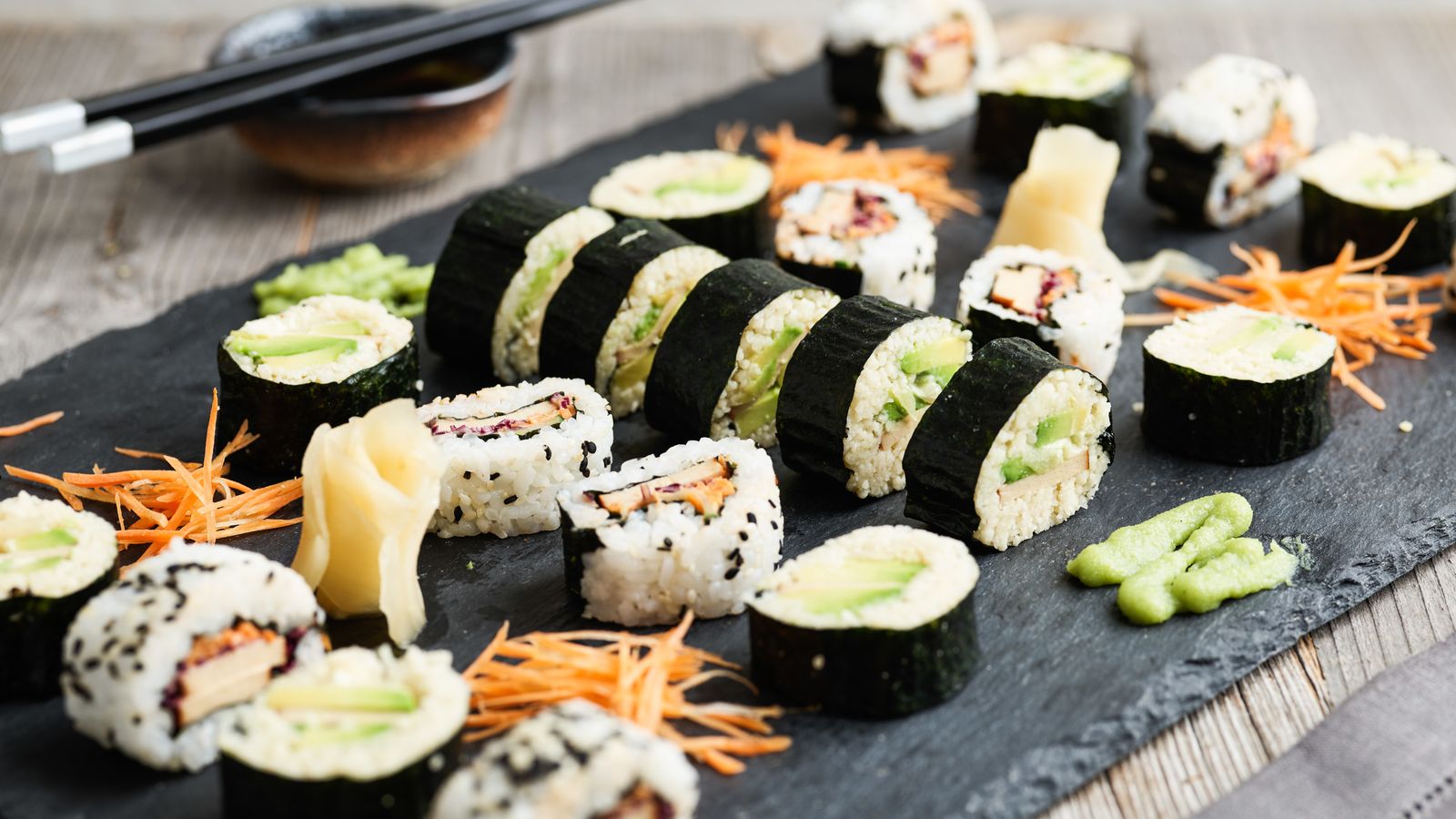 Sushi mit Reis auf einer Schieferplatte serviert
