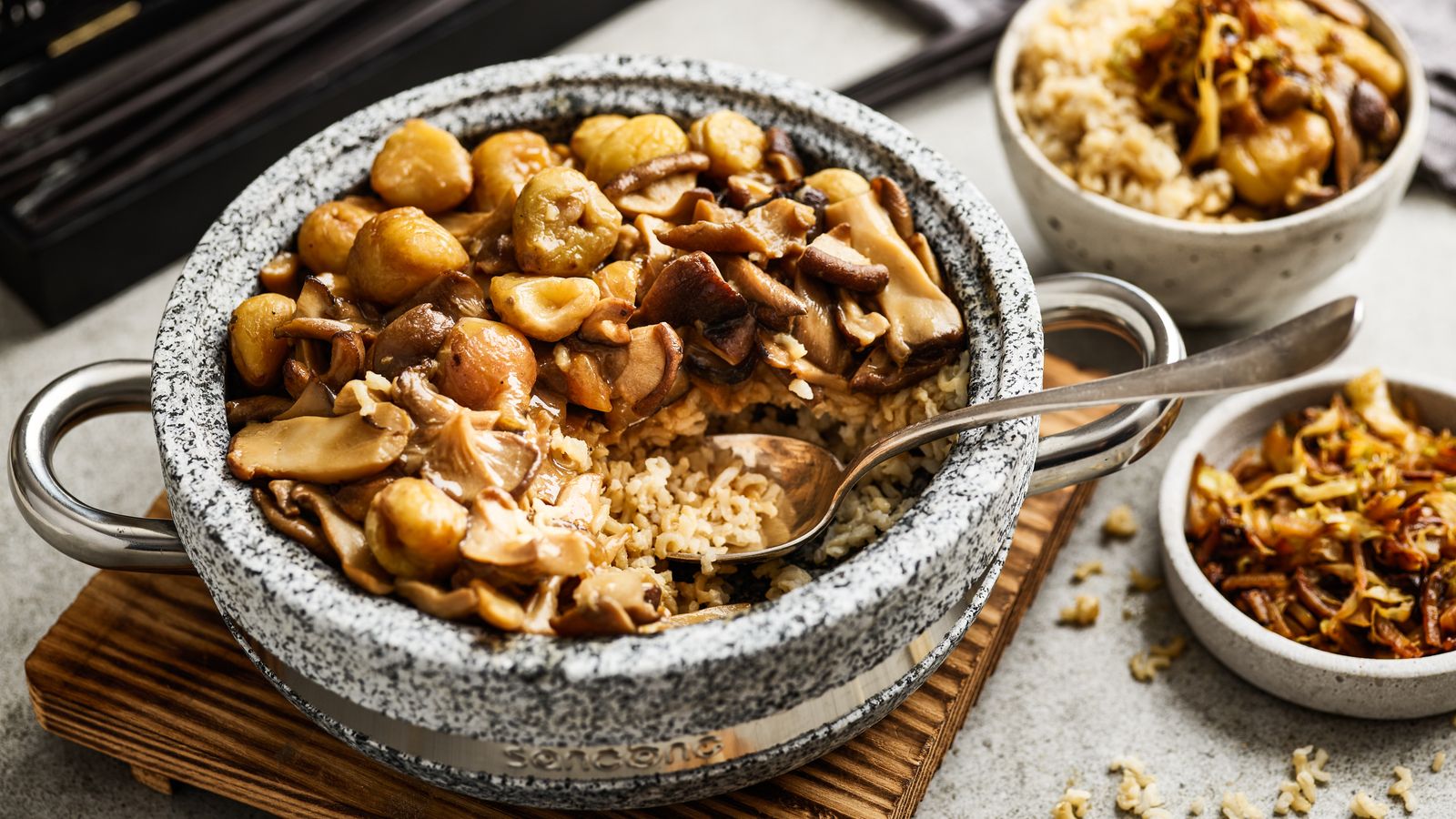 Reisgericht mit Pilz-Maronen-Ragout in einem Steintopf serviert