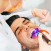 Zahnärztin macht eine komposite Zahnfüllung bei einem Patienten