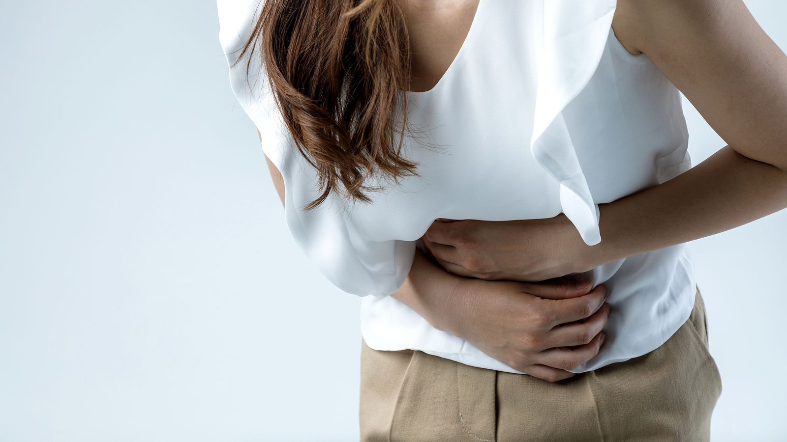 Frau hält sich den Magen wegen einer Gastritis