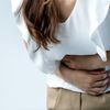 Frau hält sich den Magen wegen einer Gastritis