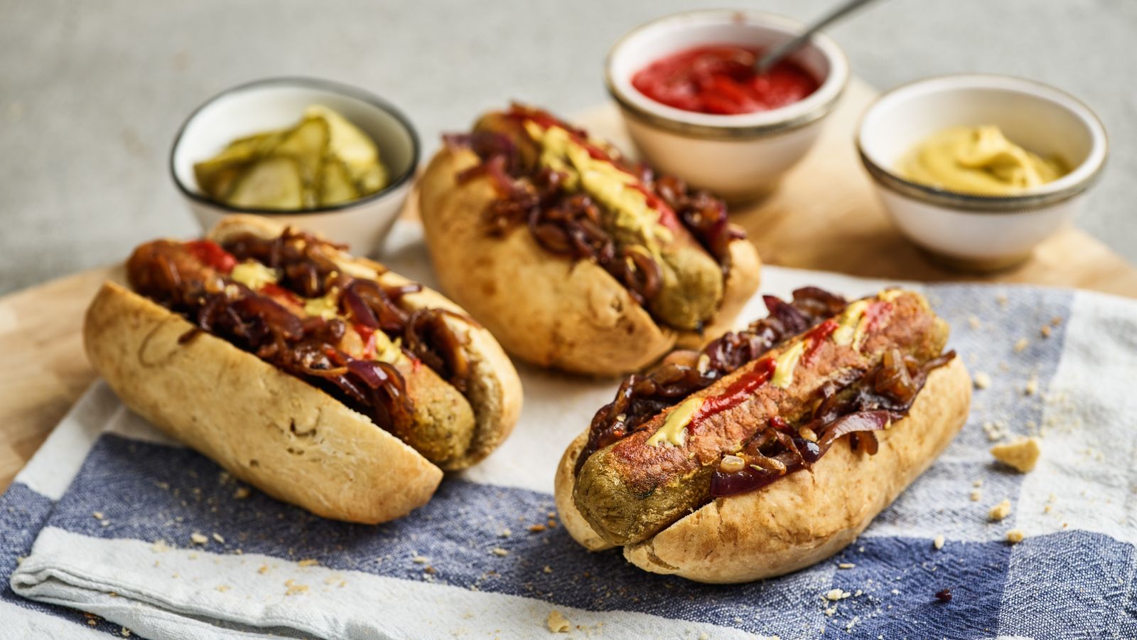 Hot Dogs hübsch serviert mit Saucen und Gürkchen