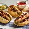 Hot Dogs hübsch serviert mit Saucen und Gürkchen