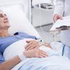 Frau liegt während einer Chemotherapie-Behandlung in einem Krankenhausbett