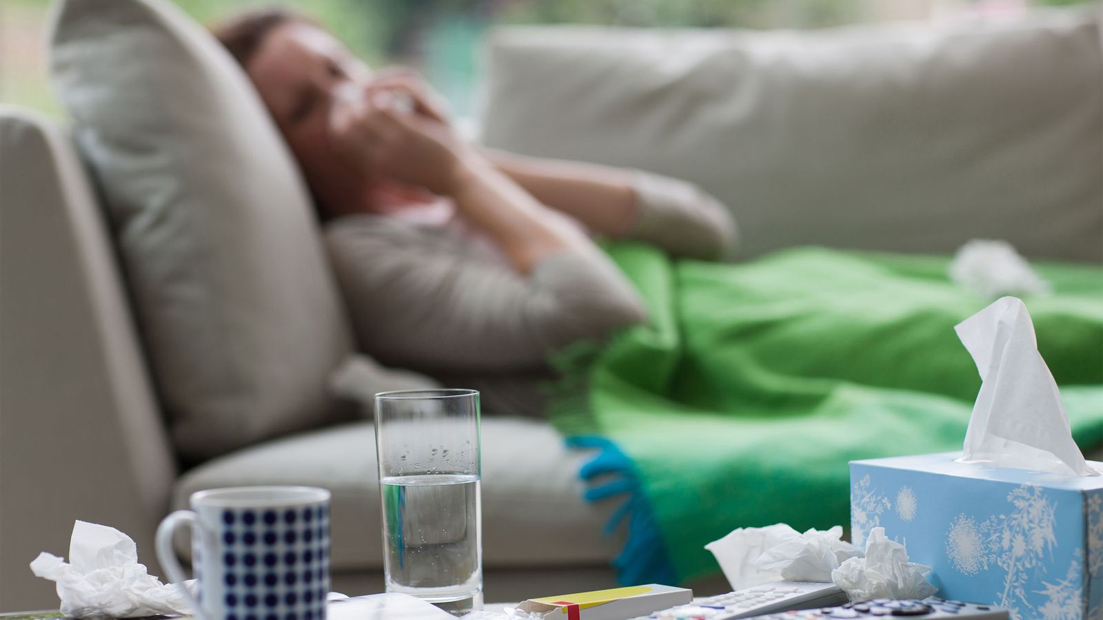 Eine Frau liegt mit Grippe im Bett