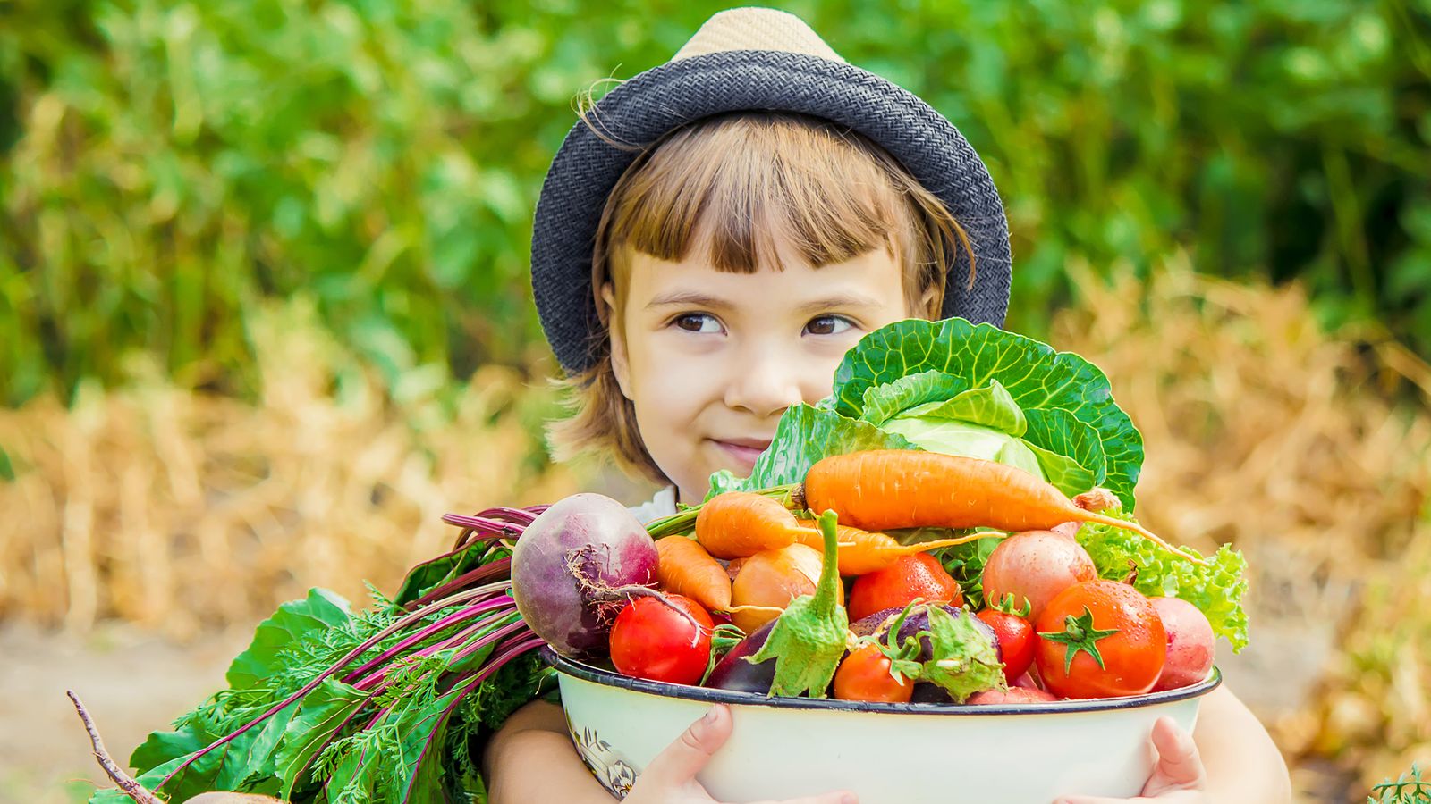 Kind hält eine Schüssel mit Gemüse in den Händen