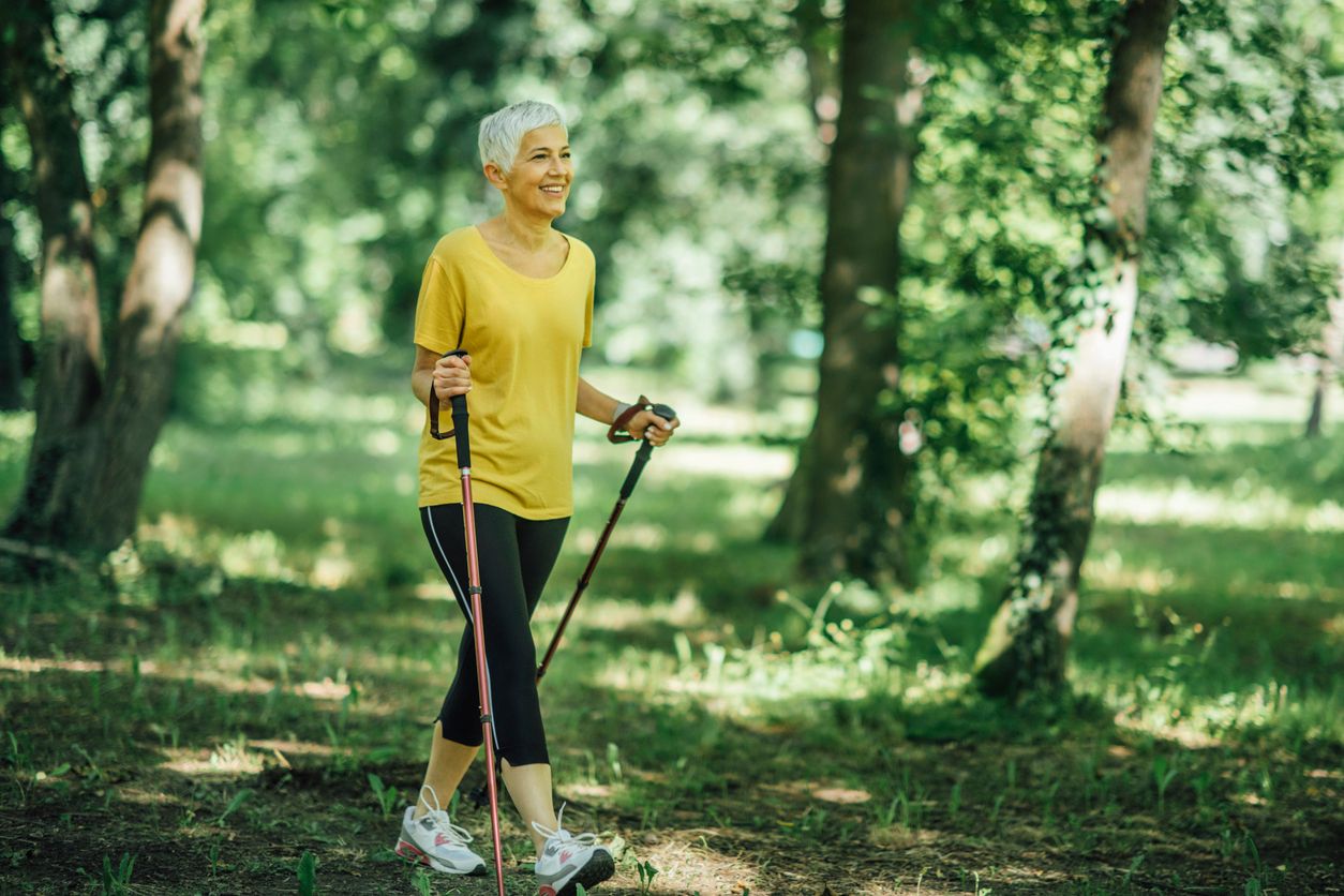 Nordic Walking Übung einer älteren Frau im Wald