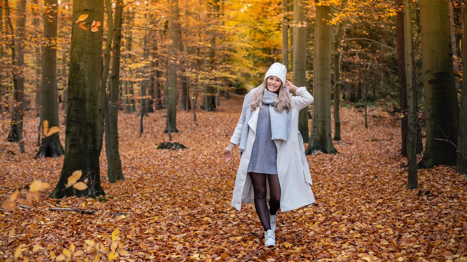 Eine junge Frau macht einen Waldspaziergang im Herbst