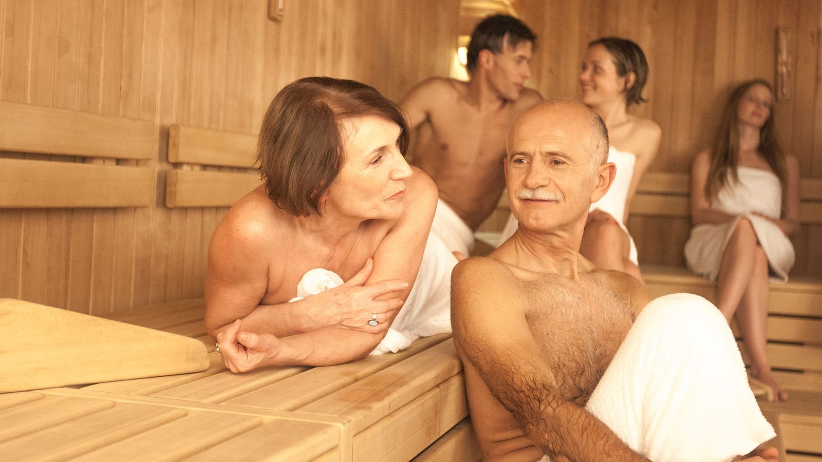 Älteres Paar sitzt entspannt in der Sauna und beugt so Demenz vor