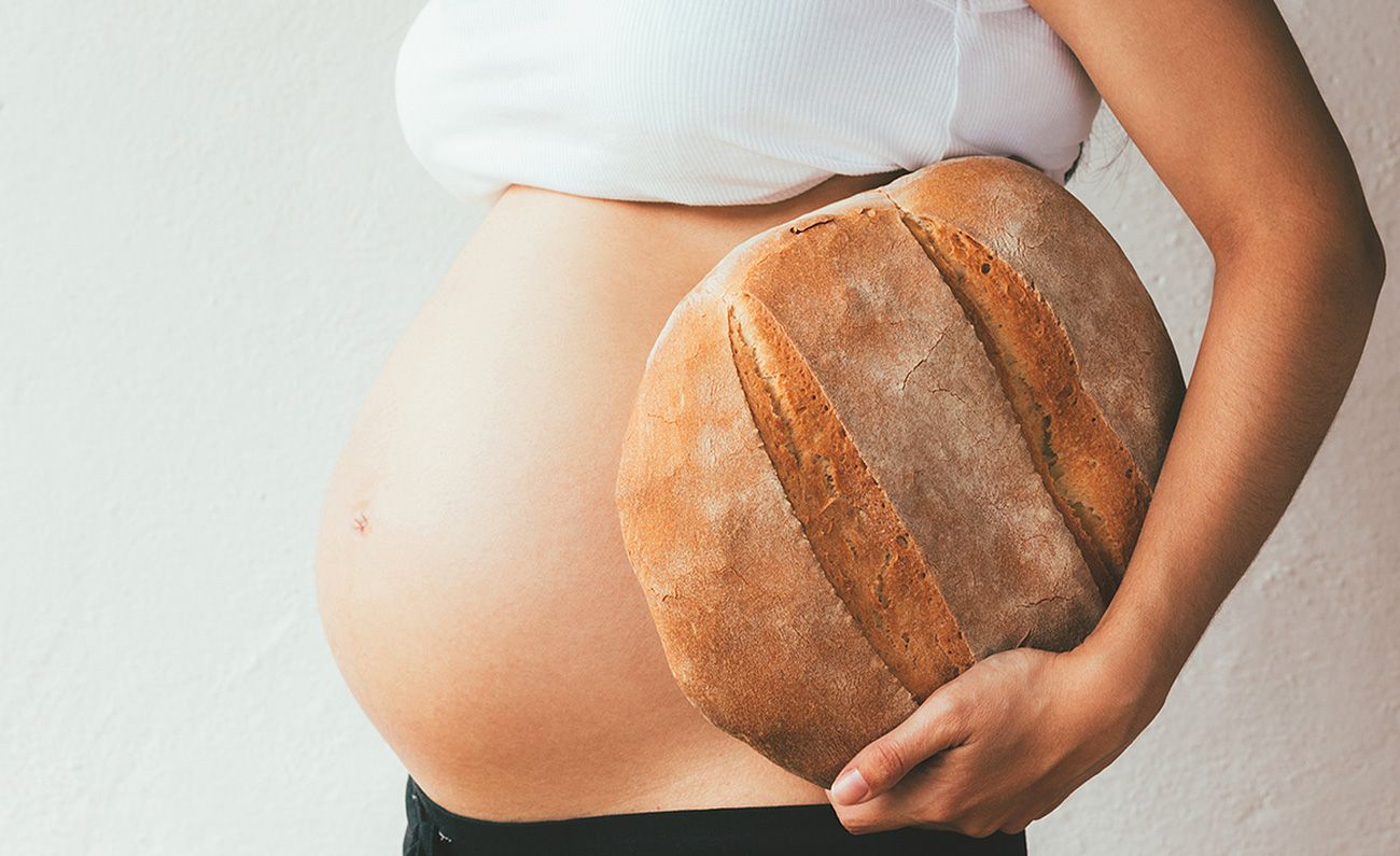 Schwangere Frau hält Brot in der Hand