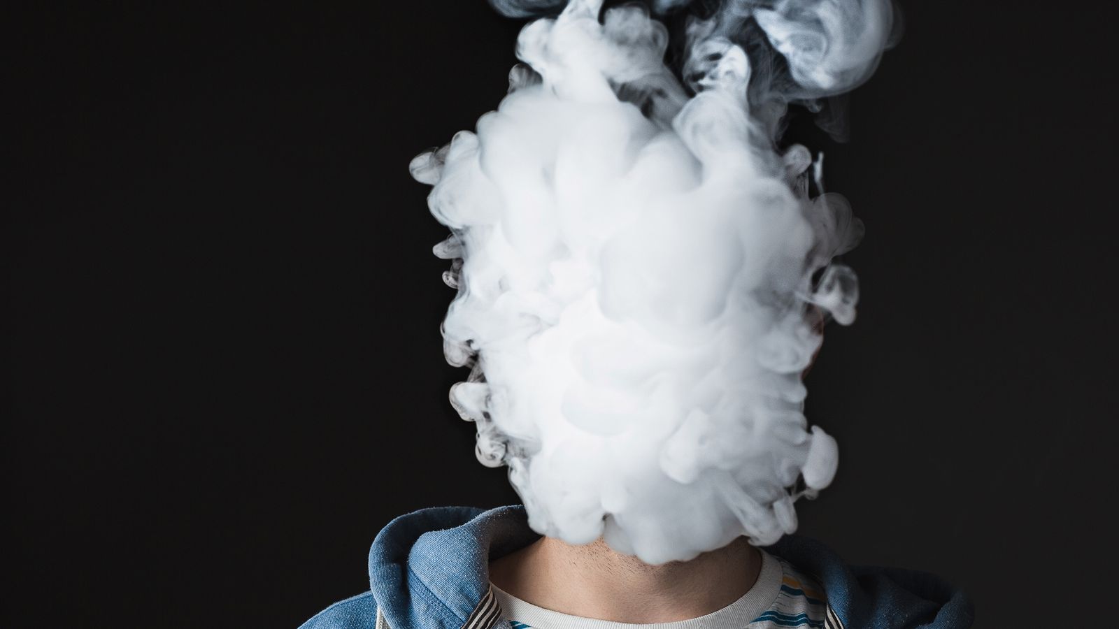 Kopf eines Mannes ist verhüllt durch E-Zigaretten Rauch