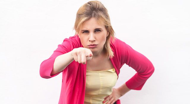 wütend aussehende Frau zeigt mit dem Finger auf dich