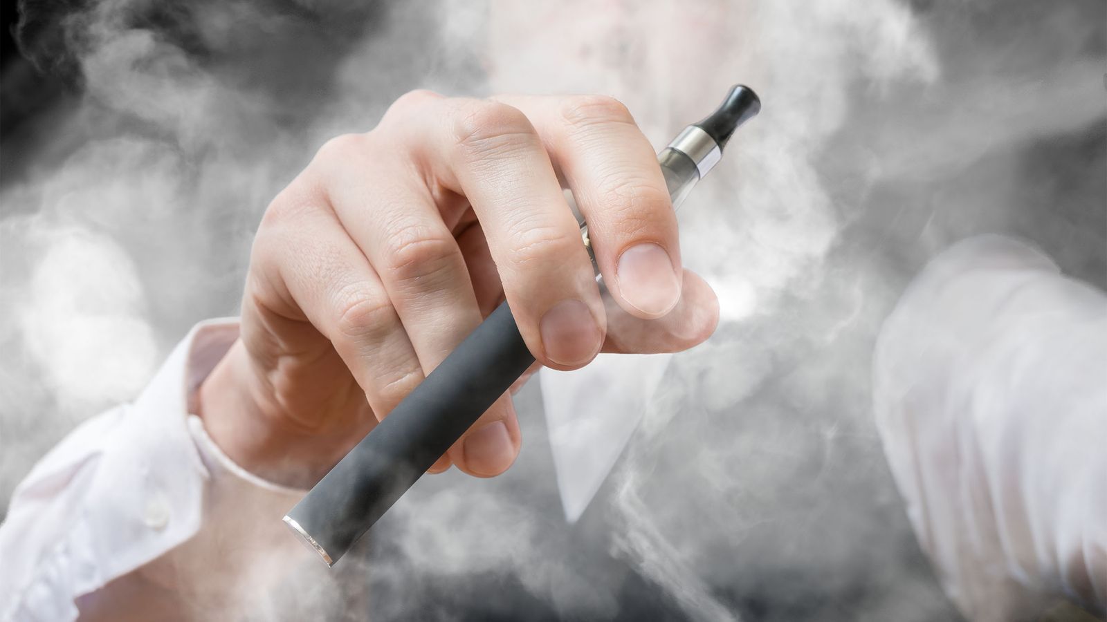 Mann dampft eine E-Zigarette und schädigt somit seinen Bronchien