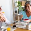 Glückliches Seniorenpaar, das ein gesundes Frühstück zu Hause genießt 
