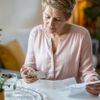 Blisterpackung mit Pillen in der Hand halten und medizinische Anweisungen lesen