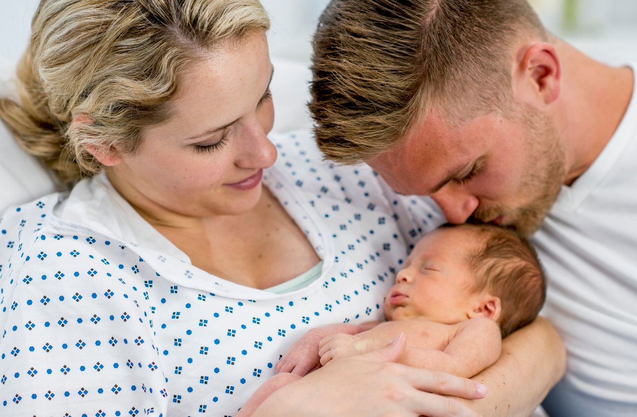 Neue Eltern halten ihr Baby