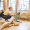 Yogalehrerin, die eine Klasse mit Entspannungsübungen leitet