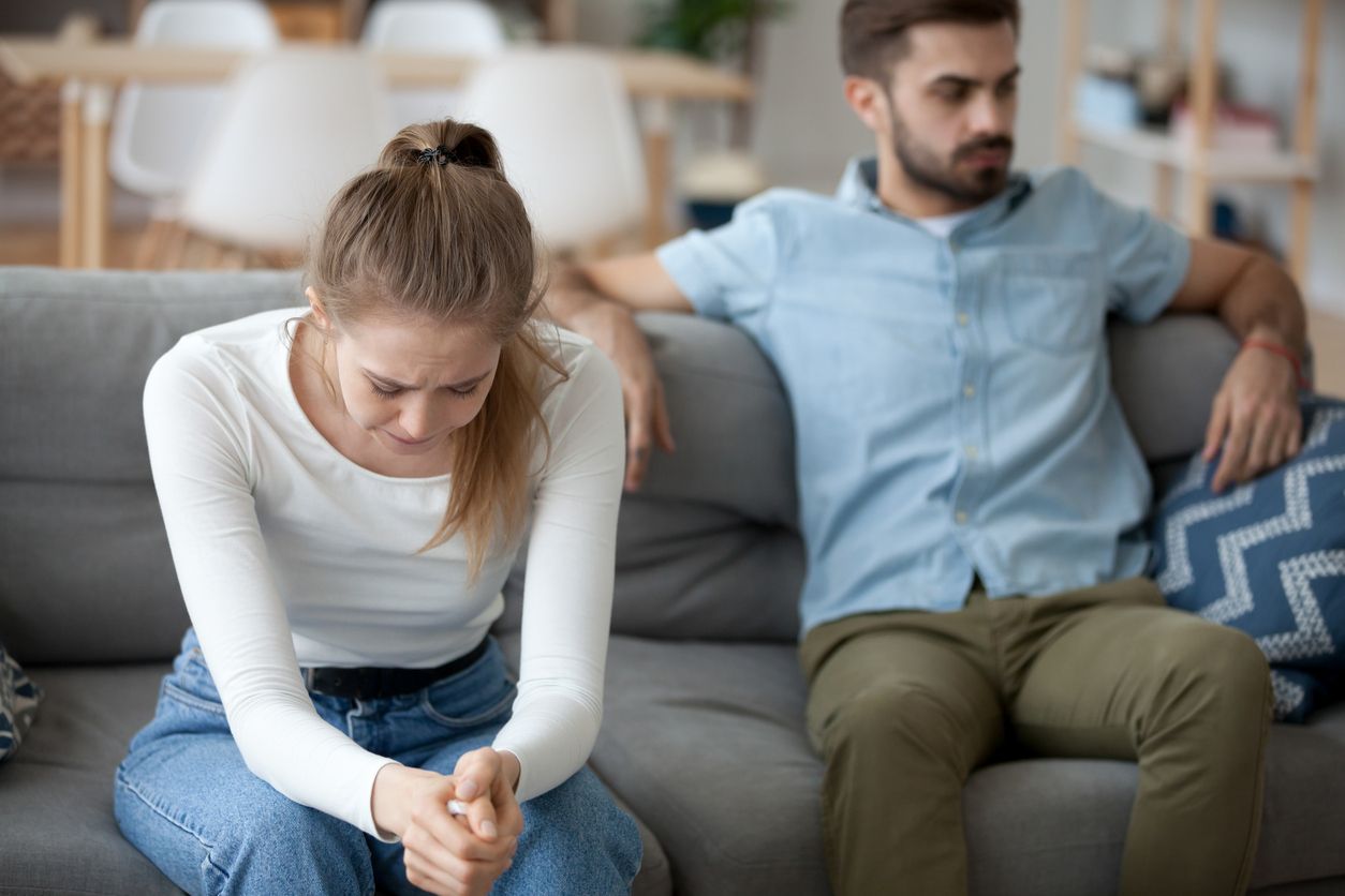 Unglückliches Paar sitzt auf der Couch