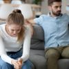 Unglückliches Paar sitzt auf der Couch