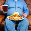 Übergewichtige Mann über Essen auf einer couch