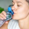 Frau trinkt aus einer Plastikflasche
