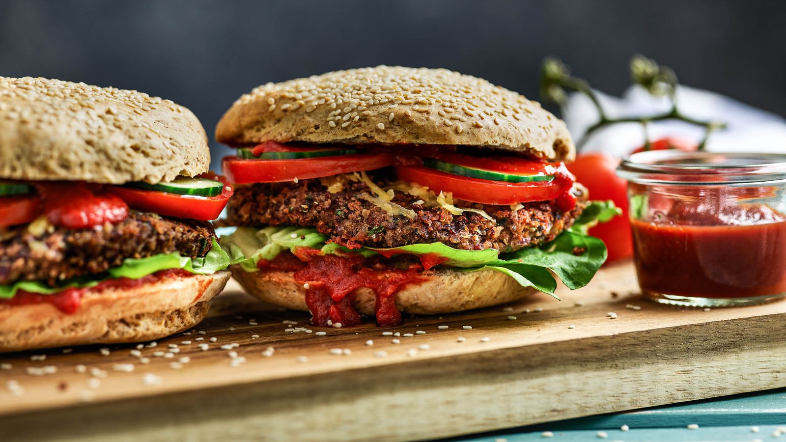 Vegane Burger aus Bohnen und Quinoa auf Holzbrett serviert