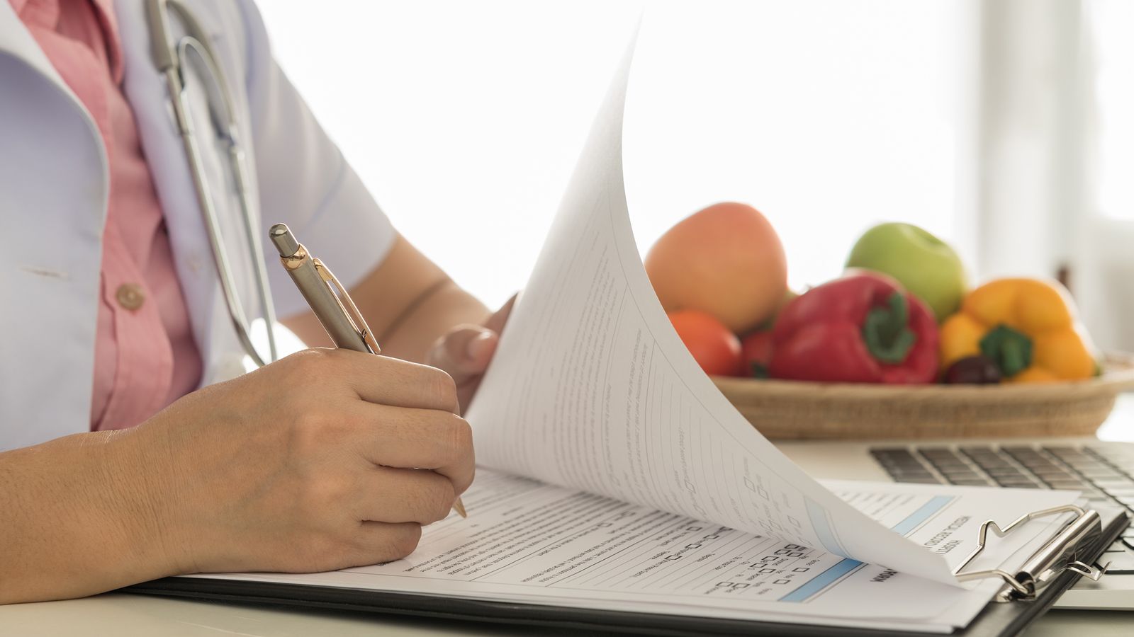 Ärztin füllt ein Formular zum Thema Ernährung aus