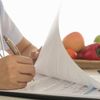 Ärztin füllt ein Formular zum Thema Ernährung aus
