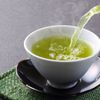 Grüner Tee wird in eine Tasse gegossen