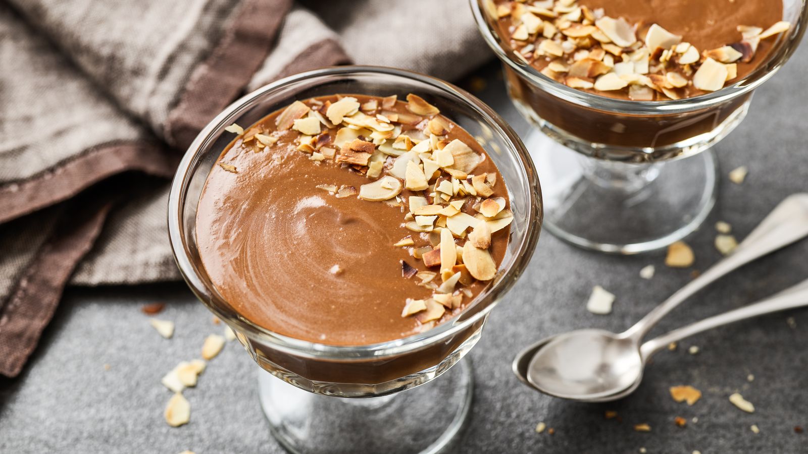 Carobpudding mit Mandelsplittern in Glasschälchen serviert