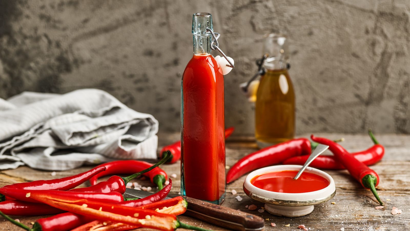 Chilisauce in einer Flasche und Chilis