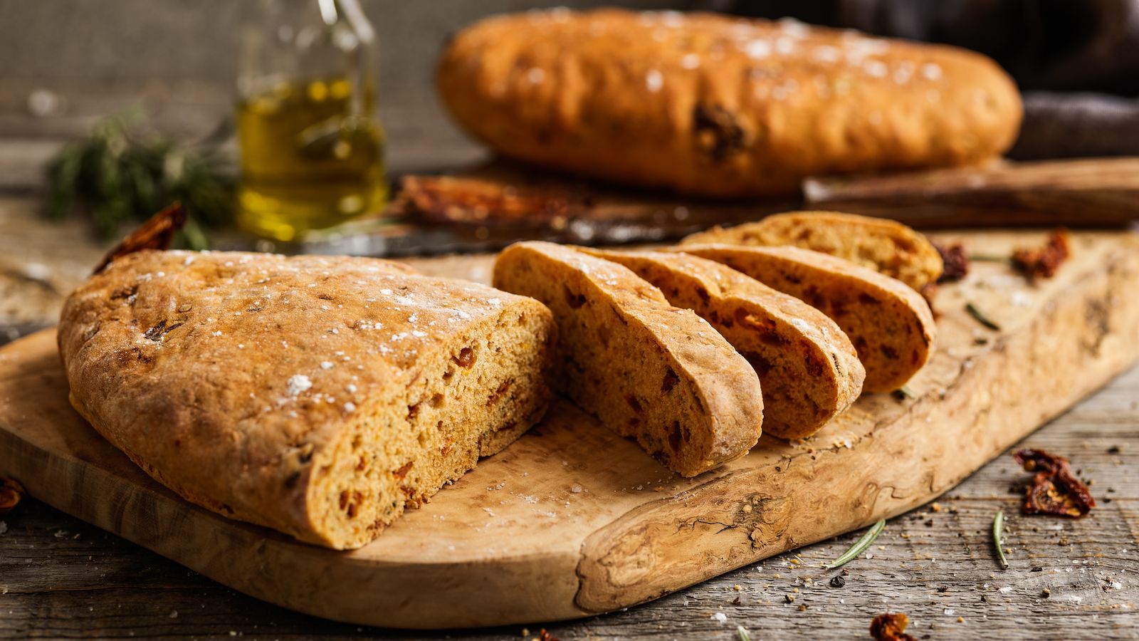 Ciabatta mit getrockneten Tomaten auf einem Holzbrett serviert