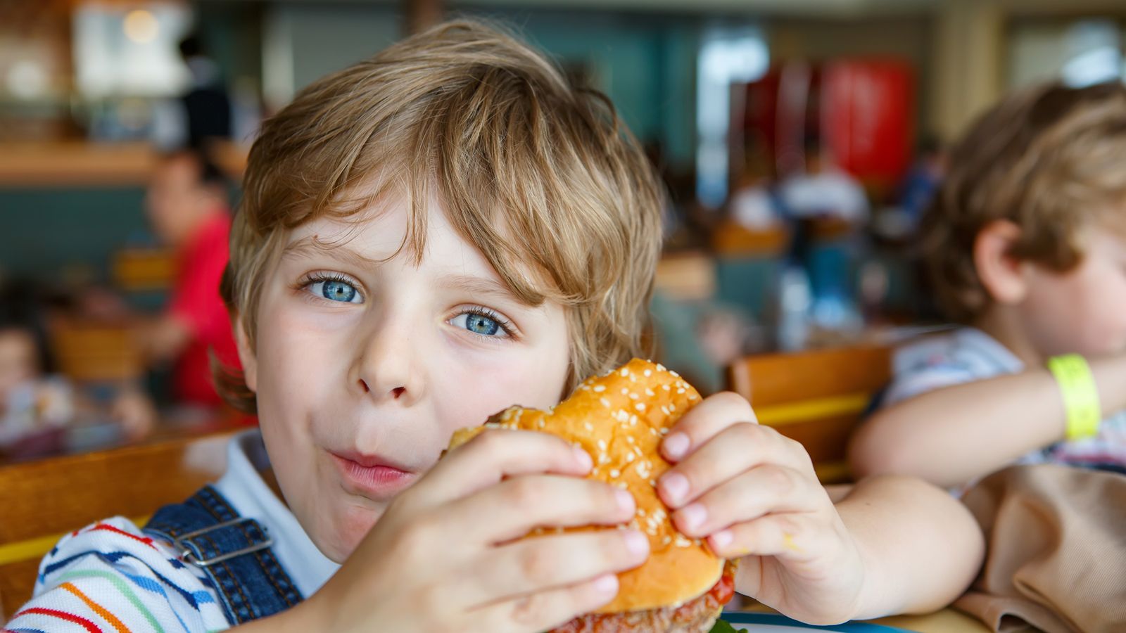 Ein Kind isst ungesunder Burger