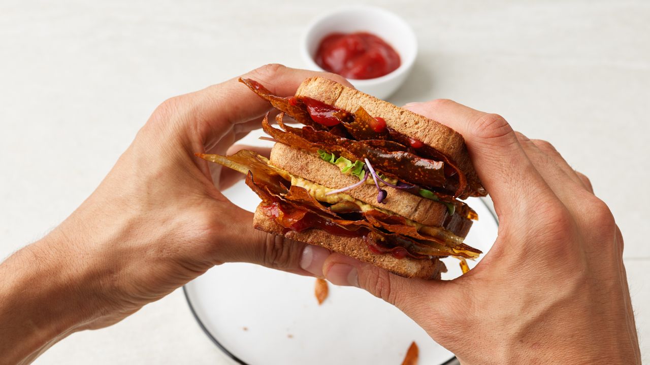 Sandwich mit Speck und Ketchup auf einem weissen Teller