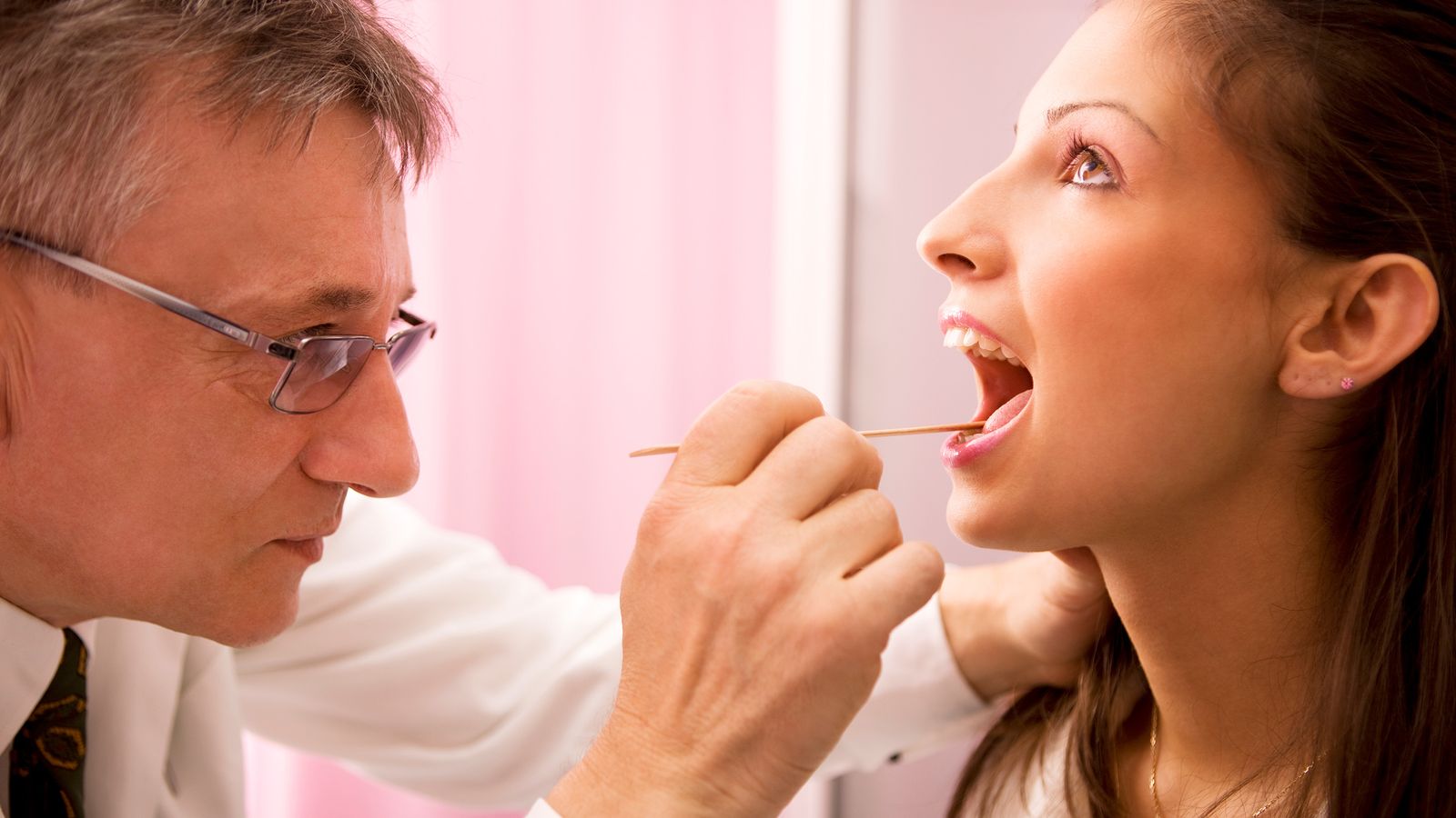 Arzt untersucht die Zunge einer Frau