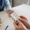 Arzt, der dem älteren Patienten in der Klinik Ratschläge zur Medikation gibt 