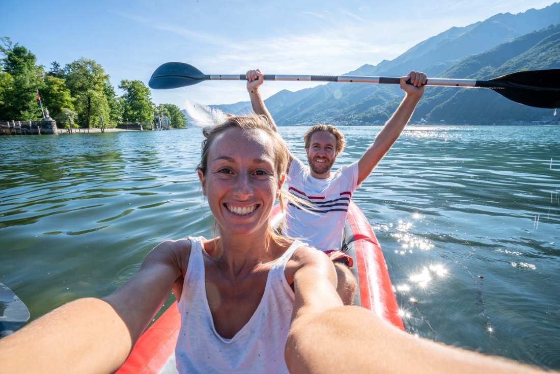 Junges Paar unter Selfie Porträt in rotem Kanu am Bergsee