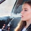 Frau raucht E-Zigarettei m Auto