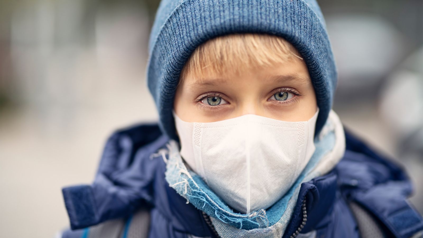 Ein Kind schützt sich mit einer Maske vor der Luftverschmutzung