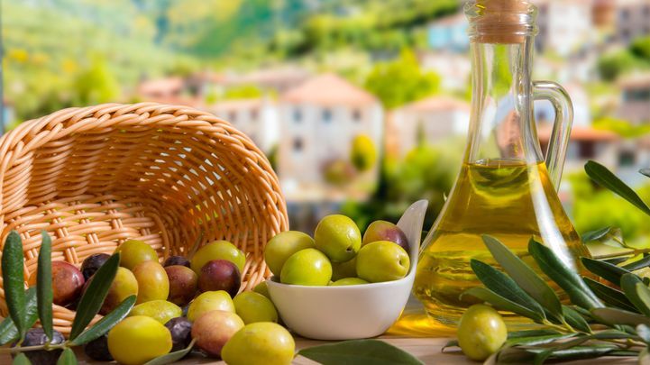 Oliven in einem Korb und Olivenöl