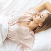 Frau liegt schlafend im Bett