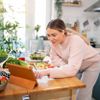 Schwangere Frau macht Salat, während sie dem Online-Rezept auf einem digitalen Tablet folgt