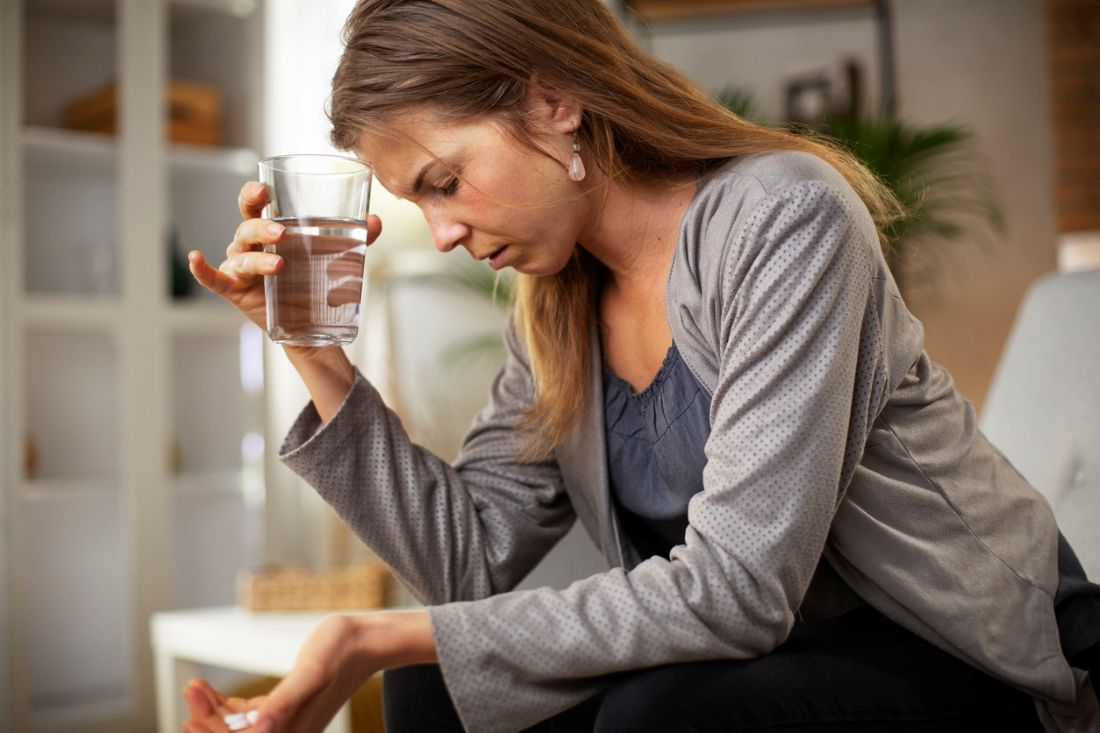 Frau, die auf dem Sofa sitzt und Magnesium in der Hand hält