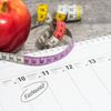 Kalender auf dem ein Apfel liegt