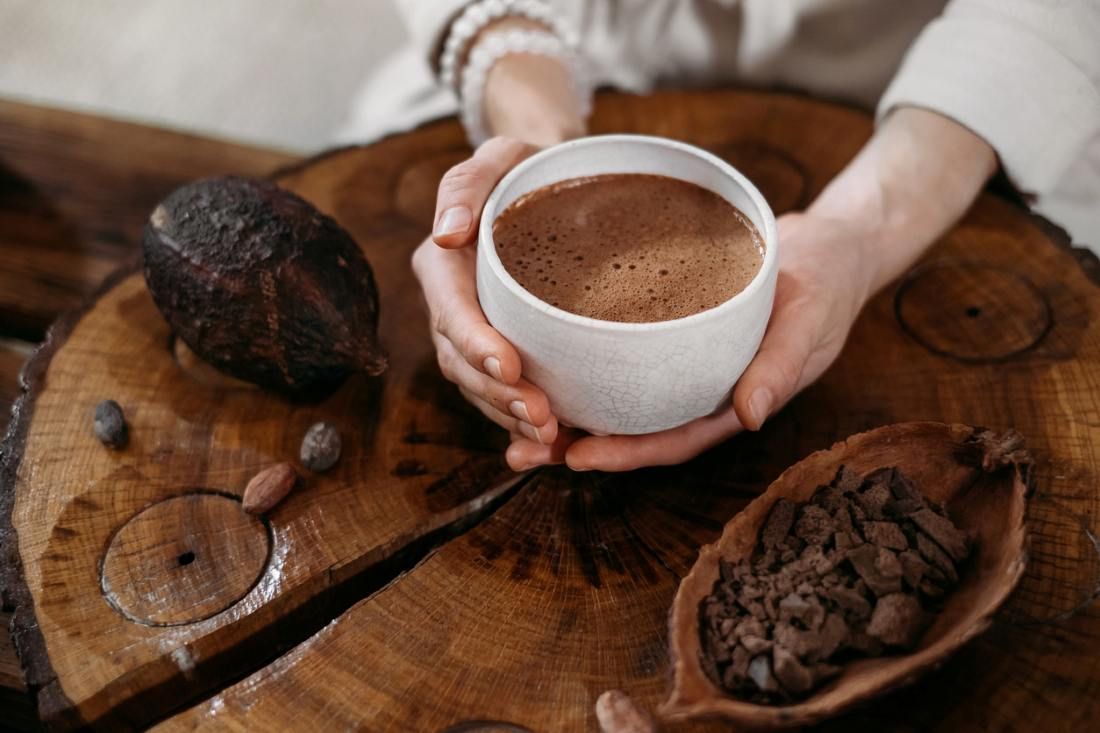 Person, die zeremoniellen Kakao in der Tasse hält