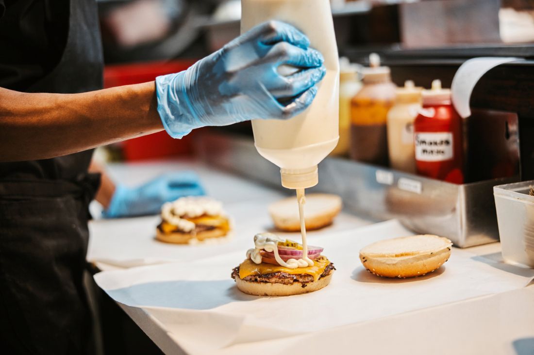  Sandwich und Koch mit Hamburger-Patty zum Mittagsservice